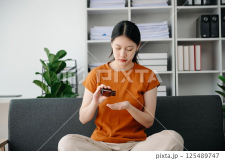 Asian woman sit Depression Dark haired  pensive glance Standing by window and anxiety Copy space. 125489747