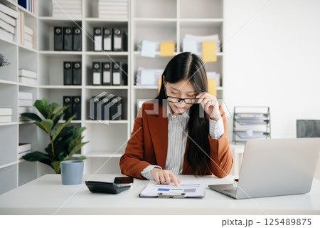Woman who is tired and overthinking from working with tablet and laptop at modern office. 125489875