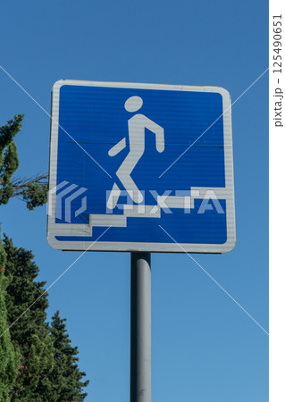 Pedestrian underpass road sign against blue sky. Pedestrian underpass road sign against blue sky. 125490651