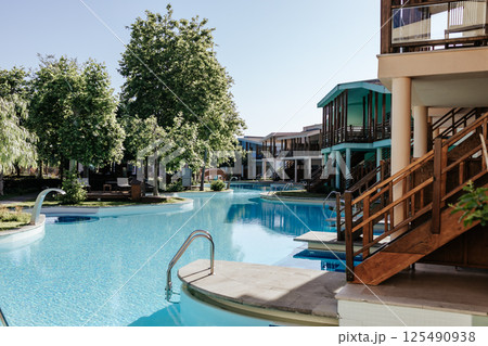 A tropical resort with private villas and direct access to the pool. Cozy wooden terraces, turquoise water, and a warm atmosphere of relaxation. An elite resort complex with crystal clear water. 125490938