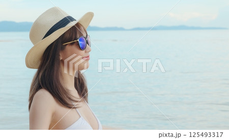 Beautiful Asian woman wearing hat and sunglasses at tropical paradise beach and smiling, Happy female in bikini swimsuit having fun eyewear in holidays summer vacation travel Beautiful Asian woman wearing hat and sunglasses at tropical paradise beach and smiling, Happy female in bikini swimsuit having fun eyewear in holidays summer vacation travel 125493317