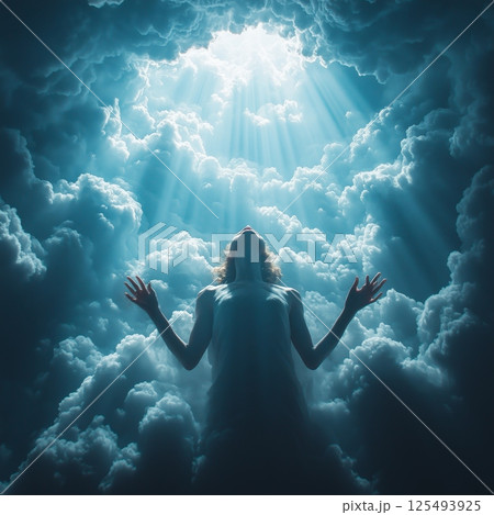 Person bathed in radiant light rays breaking through clouds 125493925