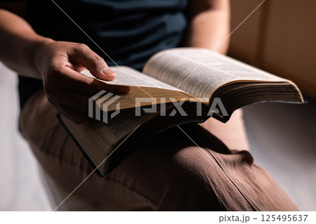 Woman of faith holds the Bible in her hand, believing deeply in the teachings of Jesus Christ and the presence of God, embodying her Christian religion. bible, person, hand, religion, book, faith. 125495637