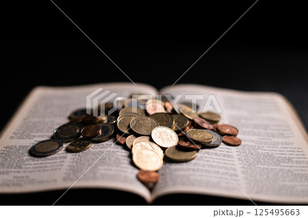 A passage in the Bible emphasizes the virtue of charity, encouraging people to give coins and donations, demonstrating the intersection of finance, religion, and the spirit of giving. coin, bible. A passage in the Bible emphasizes the virtue of charity, encouraging people to give coins and donations, demonstrating the intersection of finance, religion, and the spirit of giving. coin, bible. 125495663