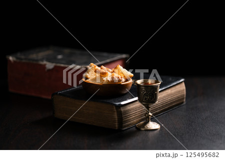 Communion, Christians celebrate their faith by partaking in bread and wine, symbolizing the body and blood of Jesus Christ, as taught in the Bible and cherished in their holy religion. communion, holy 125495682