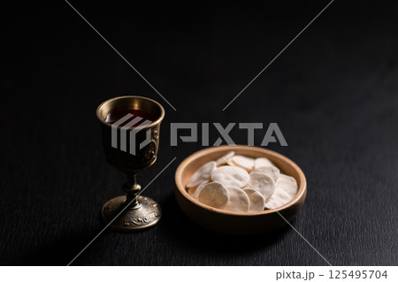 Christian religion, believers partake in Holy Communion, sacred eucharist sacrament symbolizing bread and blood of Christ, deepening their spirituality and faith. communion, christian, holy, religion 125495704