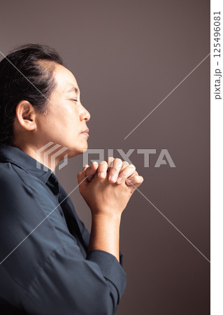 A young woman, hands clasped in prayer, meditates on her faith, seeking guidance from God and Jesus Christ in a moment of deep religious devotion. person, woman, faith, pray, prayer, hand, religion. 125496081
