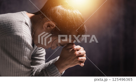 Woman clasped her hands in prayer, filled with faith and hope, believing in Jesus Christ, and seeking the holy presence of God through her prayers in the spirit of Christian religion. pray, woman. 125496365