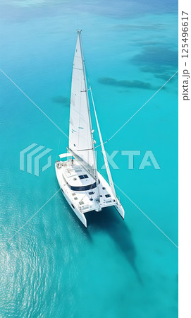 Aerial image of beautiful sailboat cruising in blue open ocean. Luxury white yacht. Generative AI 125496617