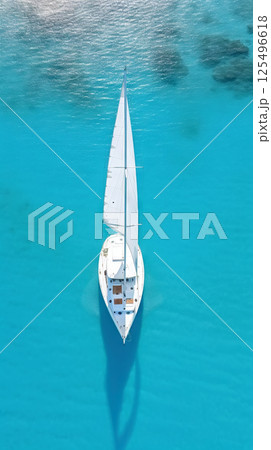Aerial image of beautiful sailboat cruising in blue open ocean. Luxury white yacht. Generative AI 125496618