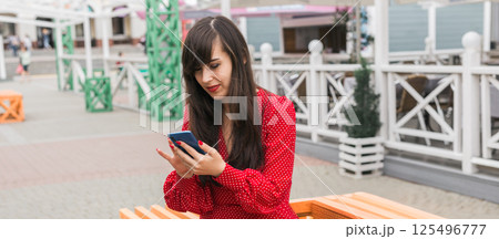 Banner woman checks phone after shopping in the city, copy space. Modern habits of reviewing shopping experiences online 125496777