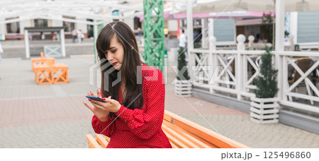 Banner woman checks phone after shopping in the city, copy space. Modern habits of reviewing shopping experiences online 125496860