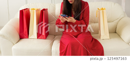 Banner Shopping with phone and card in hand sitting on sofa. Concept of e-commerce and modern consumer behavior. Copy space Banner Shopping with phone and card in hand sitting on sofa. Concept of e-commerce and modern consumer behavior. Copy space 125497163