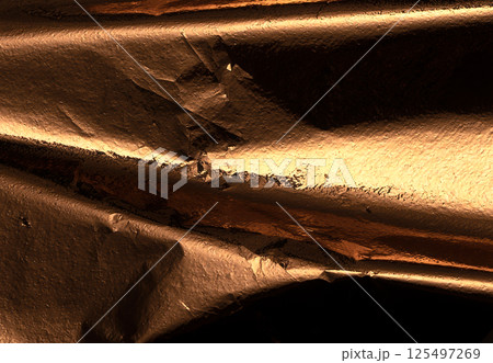 A vintage bronze foil with deep folds and crumpled texture, creating a rough, grunge pattern. This 125497269