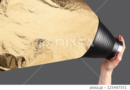 Gold foil from megaphone. Elegant metallic texture, hand holding loudspeaker for bold announcement, 125497351