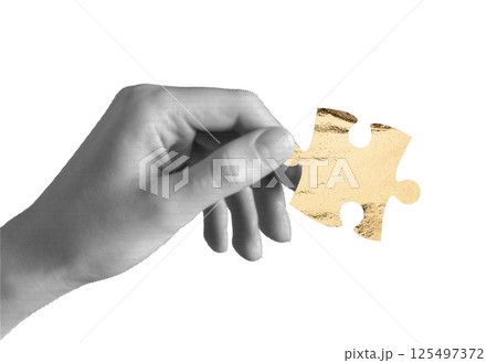 Hand holding one puzzle piece. Golden jigsaw element symbolizing idea, finance, business investment, 125497372