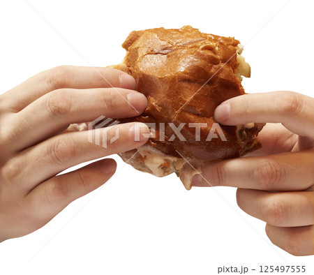 Hamburger in hands close-up on isolated background. Fast food. 125497555