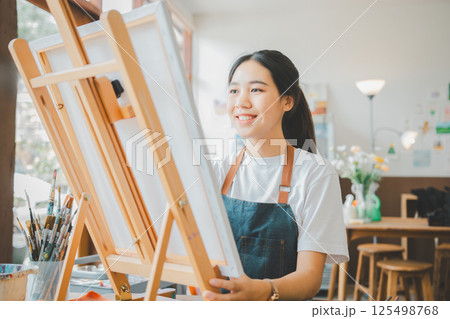 Art student drawing with watercolor painting on canvas doing some art projects on studio workshop 125498768