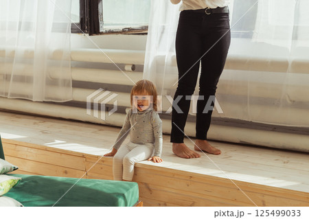 Little child playing indoors while parent works remotely. Family life and work from home concept. 125499033