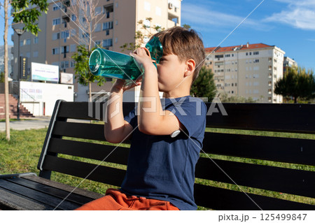 Child with diabetes hydrating outdoors on a sunny day 125499847