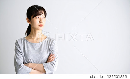 《AI画像》腕を組んで考え事をする若い女性 125501826