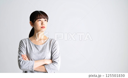 《AI画像》腕を組んで考え事をする若い女性 125501830