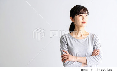 《AI画像》腕を組んで考え事をする若い女性 125501831