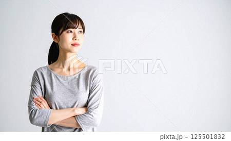《AI画像》腕を組んで考え事をする若い女性 125501832