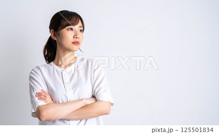 《AI画像》腕を組んで考え事をする若い女性 125501834