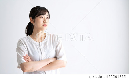 《AI画像》腕を組んで考え事をする若い女性 125501835