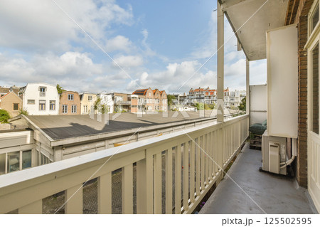 A serene balcony view showcasing an urban landscape with charming buildings and a partly cloudy sky, creating a pleasant atmosphere. A serene balcony view showcasing an urban landscape with charming buildings and a partly cloudy sky, creating a pleasant atmosphere. 125502595