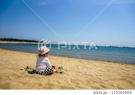 海の砂浜で砂遊びをする幼児 海の砂浜で砂遊びをする幼児 125502609