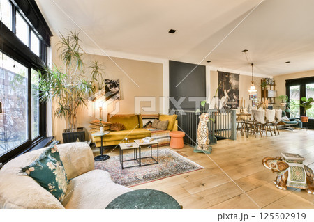 A beautifully designed living space featuring modern furniture, indoor plants, and a well-lit atmosphere that combines comfort with style. 125502919