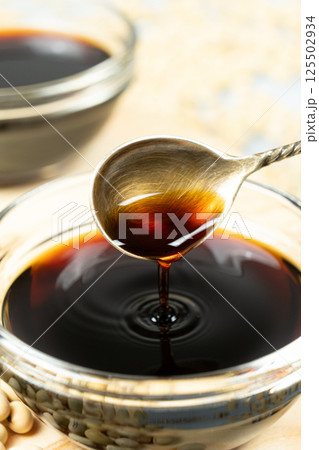 Soy sauce poured from a spoon into a saucepan close-up 125502934