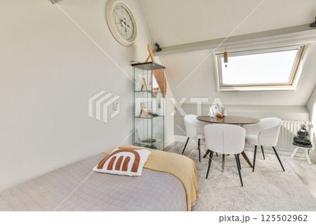 Bright and spacious interior featuring a minimalist living room with modern furnishings and natural light. A blend of comfort and aesthetics. 125502962