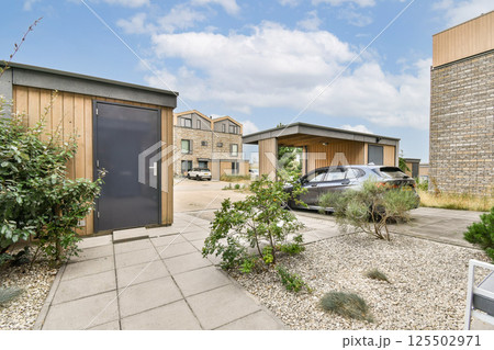 A stunning view of modern buildings surrounded by greenery, featuring a pathway and contemporary design elements. This scene showcases urban planning and nature. A stunning view of modern buildings surrounded by greenery, featuring a pathway and contemporary design elements. This scene showcases urban planning and nature. 125502971