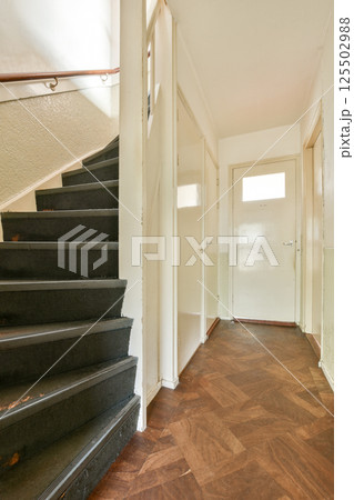 A well-lit interior showcasing a modern staircase leading to a spacious hallway, accented with sleek flooring and minimalist design elements. A well-lit interior showcasing a modern staircase leading to a spacious hallway, accented with sleek flooring and minimalist design elements. 125502988