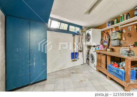 A functional and inviting laundry room featuring a combination of cabinets, a workbench, and modern appliances, enhancing efficiency in home chores. A functional and inviting laundry room featuring a combination of cabinets, a workbench, and modern appliances, enhancing efficiency in home chores. 125503004