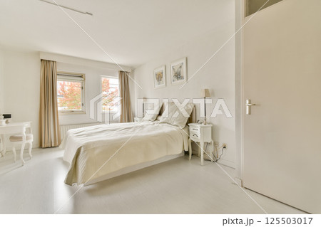 A serene and elegantly designed bedroom featuring soft neutral colors, natural light, and minimalistic decor, perfect for relaxation and comfort. A serene and elegantly designed bedroom featuring soft neutral colors, natural light, and minimalistic decor, perfect for relaxation and comfort. 125503017