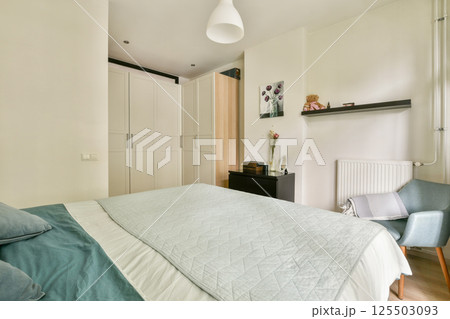 This modern bedroom features a sleek design with a soft color palette, comfortable bedding, and stylish furniture, creating a serene and inviting atmosphere. 125503093
