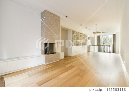 A spacious, minimalist interior featuring a light wooden floor, elegant decor, and a stylish fireplace. The room exudes tranquility and modernity. A spacious, minimalist interior featuring a light wooden floor, elegant decor, and a stylish fireplace. The room exudes tranquility and modernity. 125503118