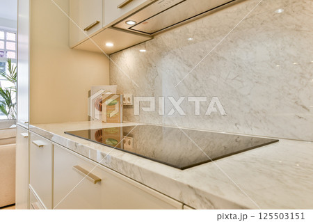 A beautifully designed modern kitchen featuring sleek marble countertops, contemporary cabinetry, and a spacious layout filled with natural light. A beautifully designed modern kitchen featuring sleek marble countertops, contemporary cabinetry, and a spacious layout filled with natural light. 125503151