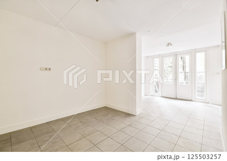 an empty living room with tile flooring and sliding glass door leading to the patio area in this apartment building an empty living room with tile flooring and sliding glass door leading to the patio area in this apartment building 125503257