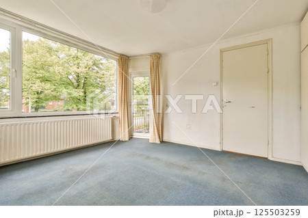 A bright room featuring large windows that allow natural light to fill the space, complemented by light-colored walls and simple decor. A bright room featuring large windows that allow natural light to fill the space, complemented by light-colored walls and simple decor. 125503259