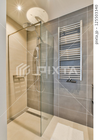 A sleek and modern bathroom featuring a glass shower enclosure, stylish wall tiles, and contemporary fixtures, creating a serene and inviting atmosphere. A sleek and modern bathroom featuring a glass shower enclosure, stylish wall tiles, and contemporary fixtures, creating a serene and inviting atmosphere. 125503340