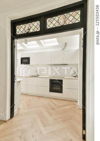 A contemporary kitchen featuring sleek cabinetry, an open layout, and elegant flooring. The space exhibits a modern aesthetic perfect for cooking and entertaining. 125503436