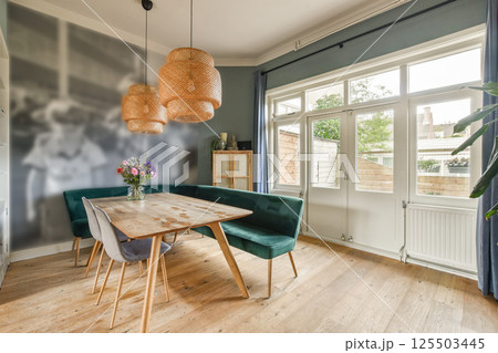 Featuring a stylish dining space with unique pendant lighting, a wooden table, and comfortable seating, perfect for gatherings and family meals. 125503445