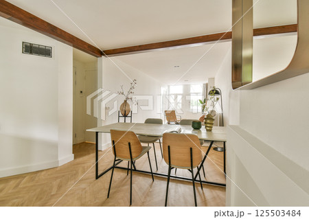 A spacious, well-lit room featuring a minimalist design with wooden accents and a simple furniture layout. Natural light enhances its tranquil ambiance. A spacious, well-lit room featuring a minimalist design with wooden accents and a simple furniture layout. Natural light enhances its tranquil ambiance. 125503484