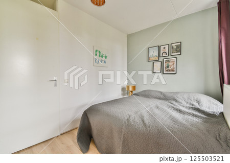 A stylish and cozy modern bedroom featuring a neatly made bed, wall art, and a warm color palette, providing a peaceful and inviting atmosphere. A stylish and cozy modern bedroom featuring a neatly made bed, wall art, and a warm color palette, providing a peaceful and inviting atmosphere. 125503521