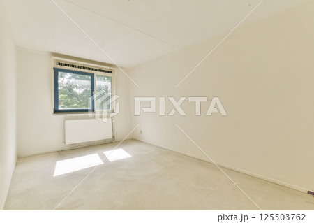 A spacious empty room featuring a large window that allows natural light to flood in, highlighting the plain walls and floor, ideal for various uses. A spacious empty room featuring a large window that allows natural light to flood in, highlighting the plain walls and floor, ideal for various uses. 125503762
